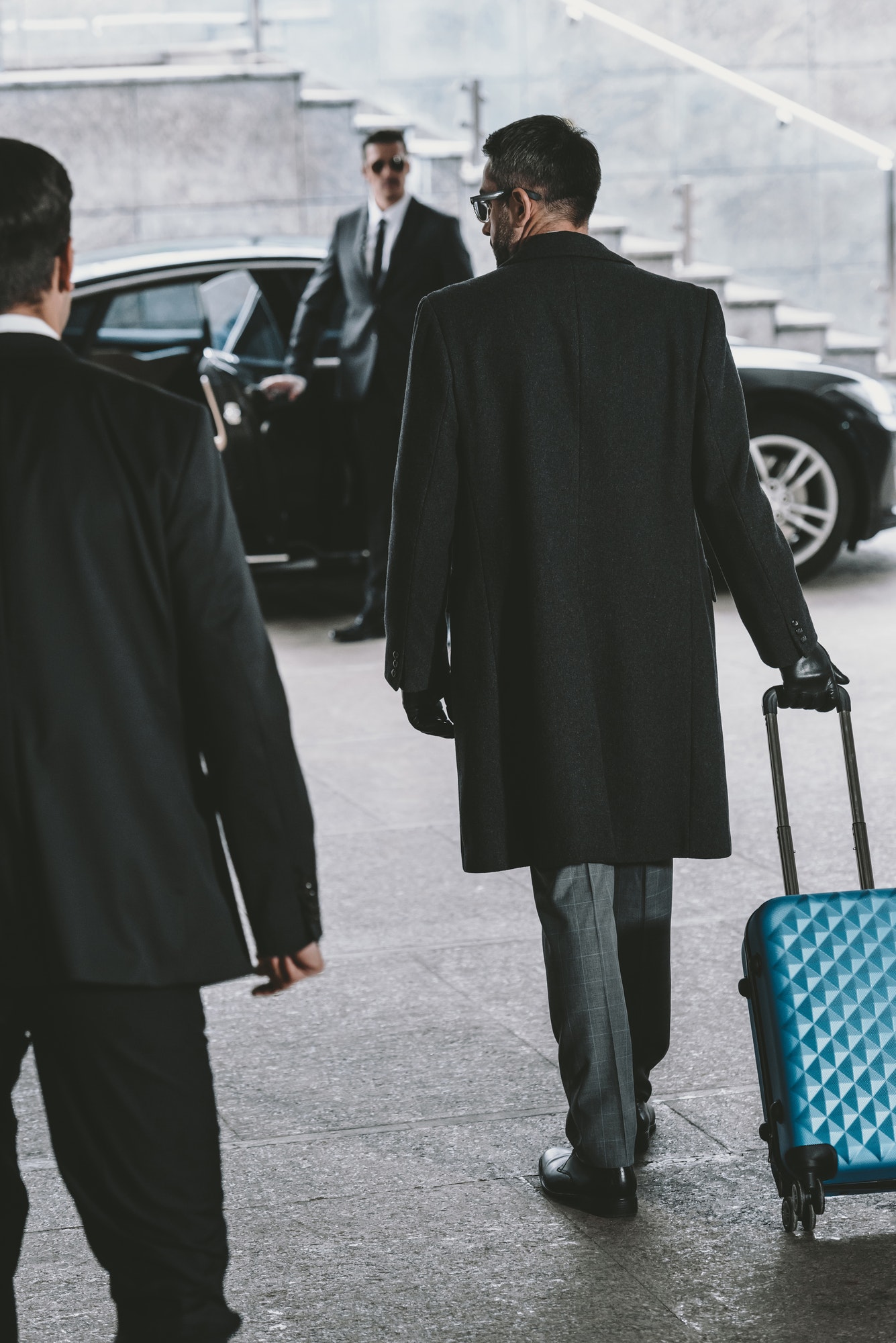 businessman-going-with-blue-travel-bag-to-car.jpg